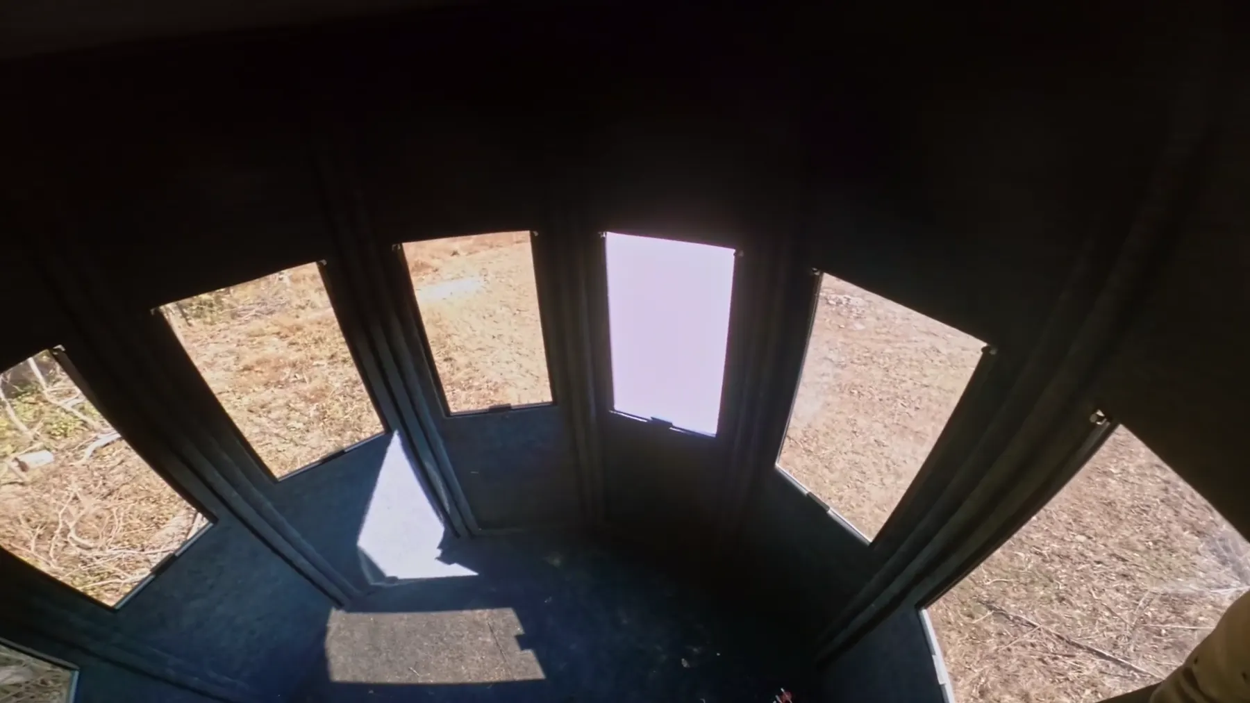 Looking up inside a blind: windows all the way around under a dark insulated ceiling.