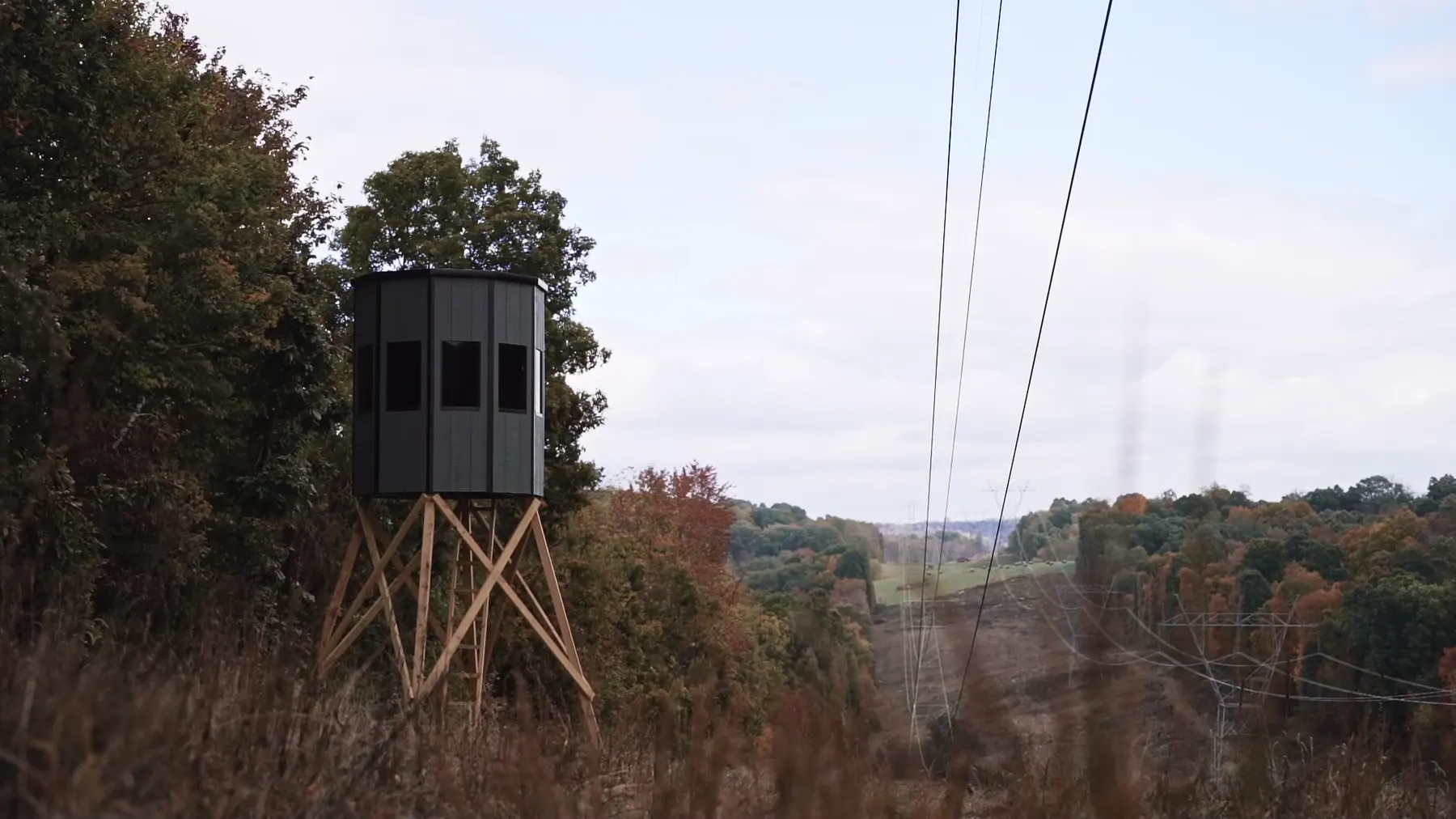 A NXTGen blind on a tower at the edge of a field.
